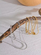 Bracelet Duo Perlé: Double chaîne dorée ornée de perles fines pour un style féminin, chic et tendance, parfait au quotidien ou en occasion spéciale. 