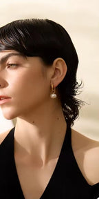 Boucles d'oreilles Perla: Perles goutte suspendues sur base dorée pour une élégance subtile et un style féminin, chic au quotidien comme en soirée. 